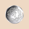 Silver coin with intricate design and branding on a white background