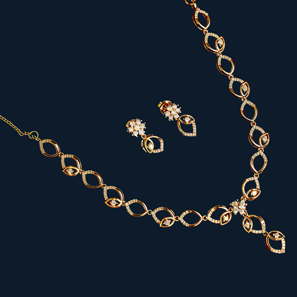 Gold plated silver necklace and earrings on a red background with flowers.