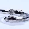 Silver ring with 'HUG ME' engraving on a white background