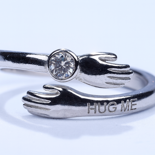 Silver ring with 'HUG ME' engraving on a white background