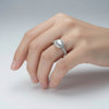 Silver ring with a diamond on a light gray background