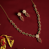 Gold necklace and earrings with floral designs on a red background