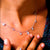 Necklace with star-shaped pendants worn by a person, close-up view.