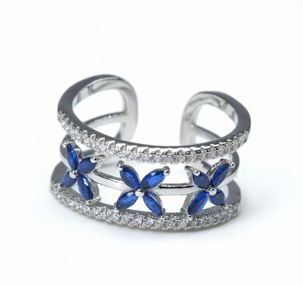 Silver ring with blue flower designs on a light gray background