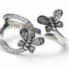 Butterfly-shaped silver ring with embedded stones on a white background