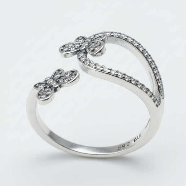 Silver butterfly-shaped ring on a light gray background