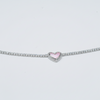 Silver bracelet with a pink heart charm on a gray background