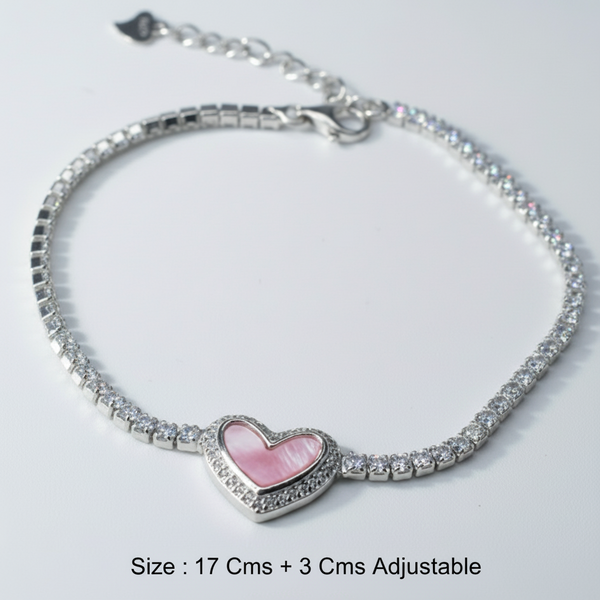 Silver bracelet with a pink heart charm on a light gray background