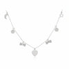 Silver necklace with heart and bow-shaped charms on a dark background
