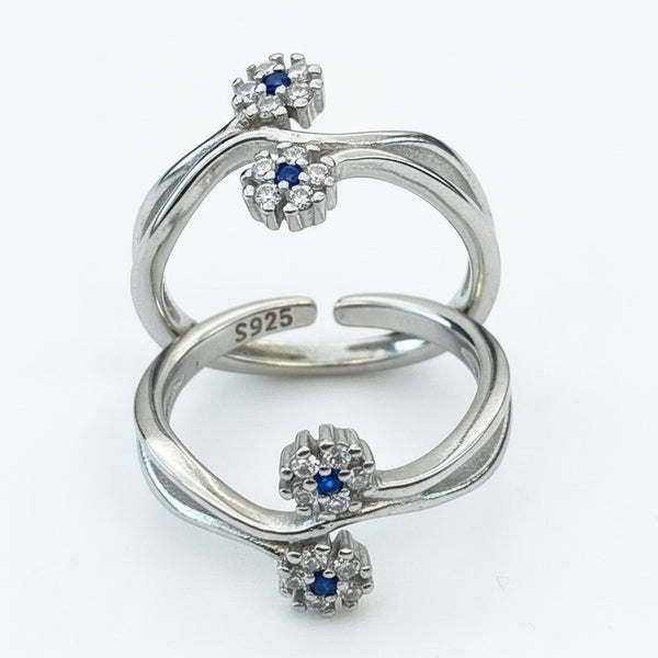 Silver ring with sapphire and diamond accents on a light background