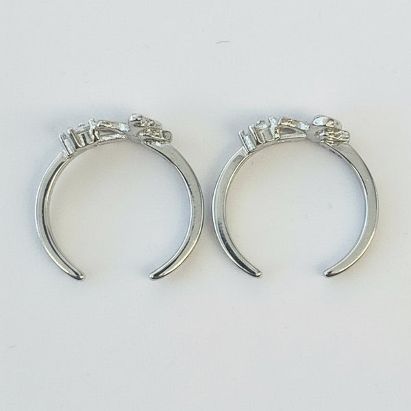 Pair of silver crescent moon earrings on a light gray background