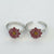 Silver hoop earrings with red flower designs on a white background