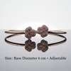 Bronze bracelet with floral designs on a reflective surface