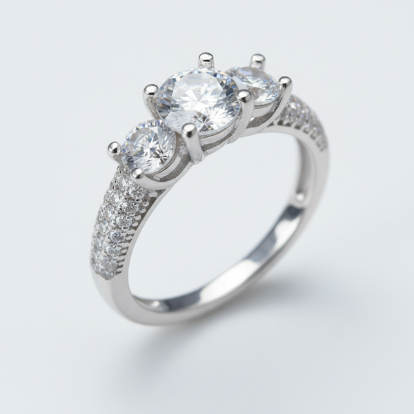 Silver ring with three clear gemstones on a light gray background