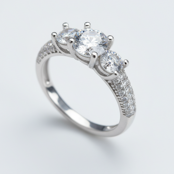 Silver ring with three clear gemstones on a light gray background