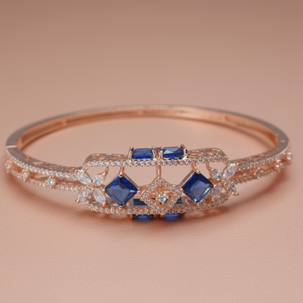 Rose gold bracelet with blue gemstones on a beige background