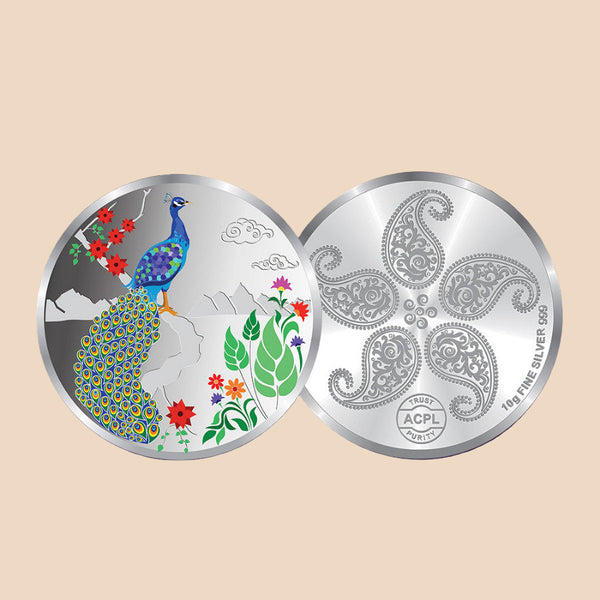Silver coin with peacock design on one side and paisley pattern on the other, against a dark purple background.