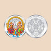 Silver coin with colorful design on one side and intricate pattern on the other, on a dark purple background.