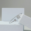 Silver bracelet with diamond accents on a white stand against a gray background