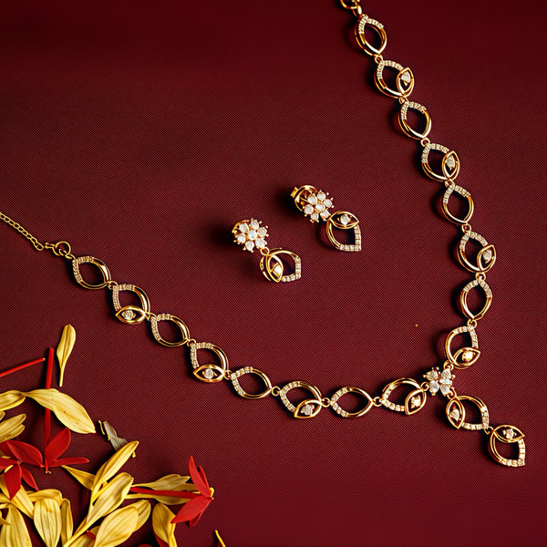 Gold plated silver necklace and earrings on a red background with flowers.