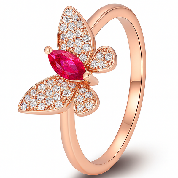 Rose gold butterfly ring with red gemstone and diamonds on a white background