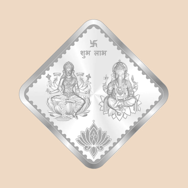 Diamond-shaped silver foil with two seated figures and a lotus design on a white background
