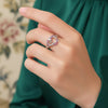 Silver ring with heart design on a finger against a soft background