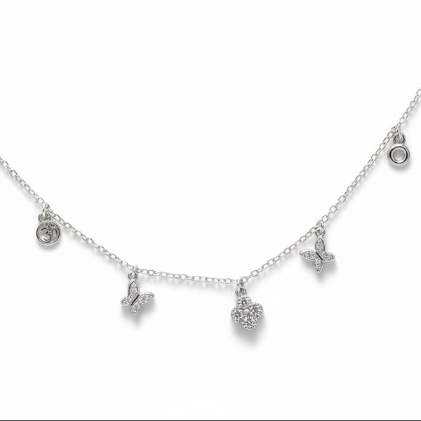Necklace with small pendants on a person wearing an orange top.