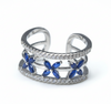 Silver ring with blue flower designs on a light gray background
