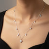 Silver necklace with small pendants on a wooden surface