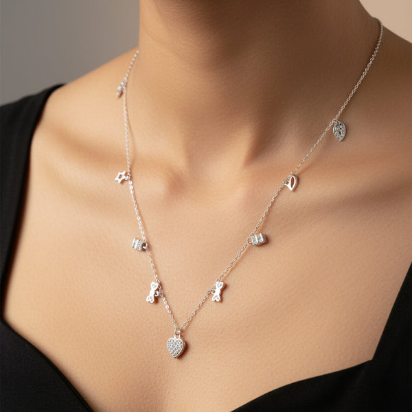 Silver necklace with small pendants on a wooden surface