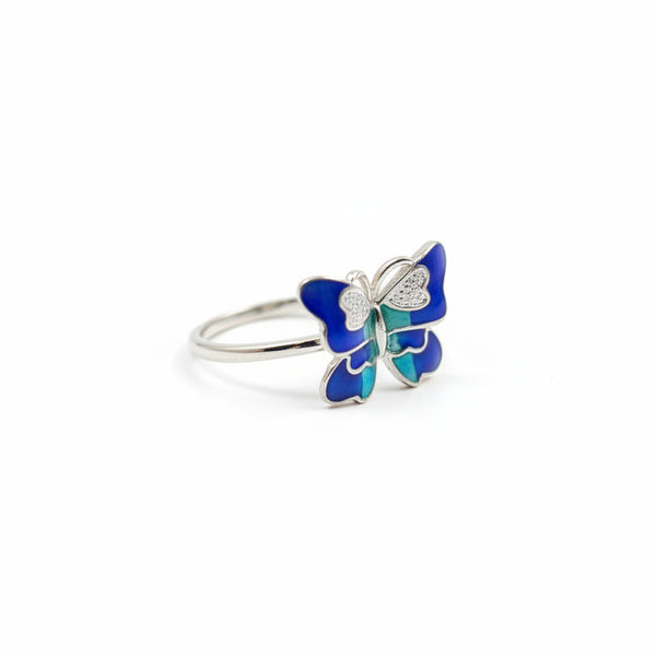 Butterfly-shaped ring with blue and green design on a white background