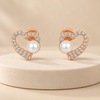 Heart-and-pearl earrings on a cream display
